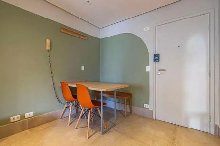 Tabela de madeira e quatro cadeiras de cor laranja em uma sala com paredes verdes e um arco no fundo. de kitnet/studio à venda com 2 quartos, 31m² em Cerqueira César, São Paulo
