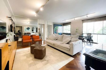Sala de estar com sofá branco, mesas e cadeiras de madeira, e paredes brancas e iluminadas. de apartamento à venda com 4 quartos, 105m² em Cerqueira César, São Paulo