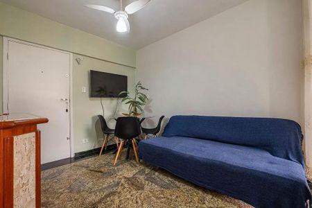 Sala de estar com sofá azul e mesa com cadeiras, TV na parede e porta de entrada. de kitnet/studio à venda com 1 quarto, 31m² em Cerqueira César, São Paulo