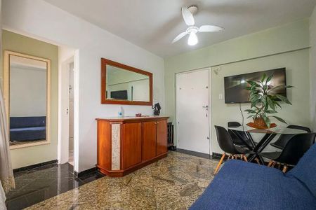 Sala de estar com sofá azul e mesa de jantar com cadeiras pretas, TV na parede e porta branca. de kitnet/studio à venda com 1 quarto, 31m² em Cerqueira César, São Paulo