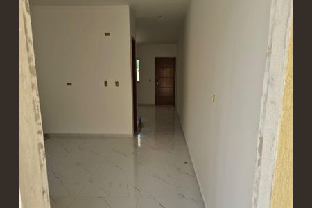 Corredor com piso de porcelanato e paredes brancas, com uma porta de madeira no final. de casa à venda com 3 quartos, 130m² em Vila Prudente, São Paulo
