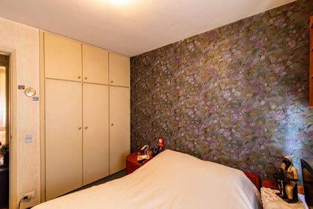 Apartamento à venda com 84m², 3 quartos e 2 vagasQuarto com cama, armários e papel de parede floral, com iluminação adequada e mobiliário simples.