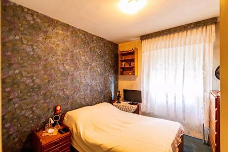 Apartamento à venda com 84m², 3 quartos e 2 vagasQuarto com cama simples, cortina branca e papel de parede floral, com mobília simples e poucos objetos de decoração.