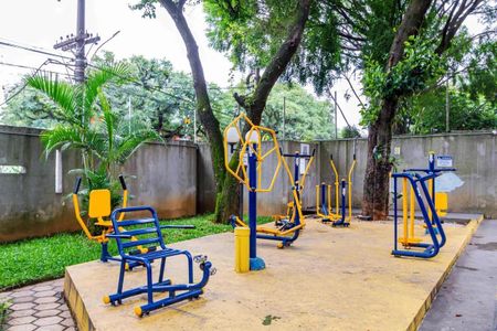 Apartamento à venda com 84m², 3 quartos e 2 vagasEquipamento de ginástica ao ar livre em um parque público, com árvores e muro de concreto ao fundo.