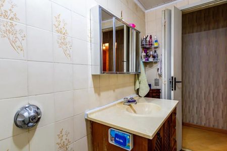 Apartamento à venda com 84m², 3 quartos e 2 vagasBanheiro com pia e espelho, com um tapete de banho e uma porta de vidro.