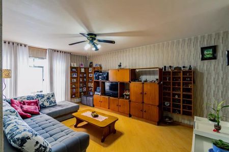 Sala de estar com sofá azul e florais, mesa de café de madeira e centro de entretenimento grande. de apartamento à venda com 3 quartos, 84m² em Casa Verde, São Paulo