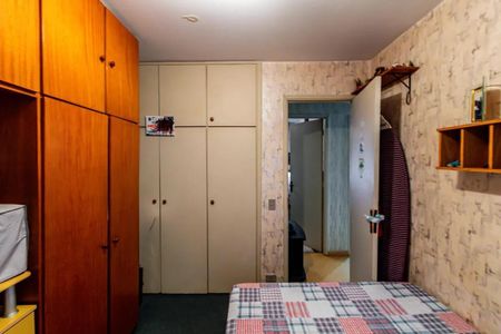 Apartamento à venda com 84m², 3 quartos e 2 vagasQuarto com móveis de madeira e um colchão com cobertor de tartan, com uma porta aberta para outro quarto.