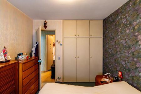 Apartamento à venda com 84m², 3 quartos e 2 vagasQuarto com móveis de madeira e papel de parede floral, com uma cama e um armário grande.