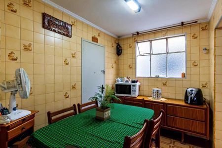 Apartamento à venda com 84m², 3 quartos e 2 vagasSala de jantar com mesa de madeira e cadeiras, com um piso de azulejos e uma janela grande.