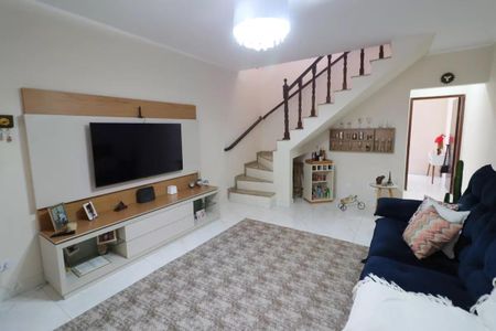 Sala com TV e sofá, com uma escada de madeira no fundo, com uma iluminação natural e uma decoração simples. de casa à venda com 3 quartos, 161m² em Jardim D’abril, Osasco