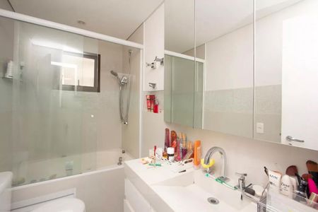 Apartamento à venda com 195m², 4 quartos e 3 vagasBanheiro com chuveiro e banheira, com móveis brancos e espelho grande.
