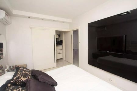 Apartamento à venda com 195m², 4 quartos e 3 vagasQuarto com cama, TV e ar condicionado, com decoração em tons de preto e branco.