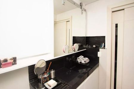 Apartamento à venda com 195m², 4 quartos e 3 vagasBanheiro com piso de porcelanato, pia de granito e espelho de roda, com uma decoração simples e minimalista.