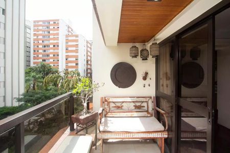Apartamento à venda com 195m², 4 quartos e 3 vagasVaranda com vista para o jardim, com móveis de madeira e plantas, iluminada por lâmpadas de design.