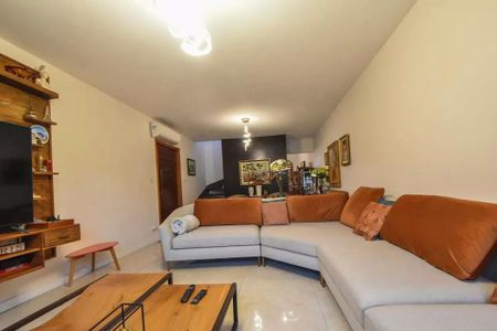 Sala com sofá, mesa de centro e TV, com decoração simples e iluminação adequada. de casa à venda com 4 quartos, 120m² em Vila Cordeiro, São Paulo