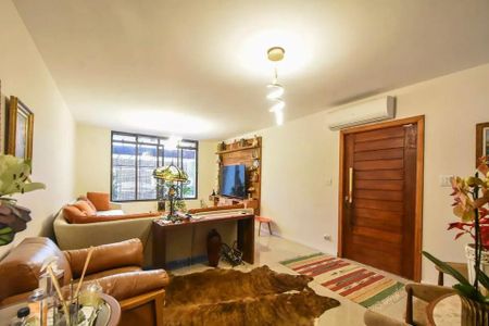Sala com sofás, mesa e TV, com vista para a rua, iluminada por lâmpadas e com um tapete de couro no chão. de casa à venda com 4 quartos, 120m² em Vila Cordeiro, São Paulo