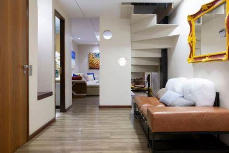 Sala de estar com sofá e escada em um apartamento moderno e bem decorado. de casa à venda com 6 quartos, 280m² em Cerqueira César, São Paulo