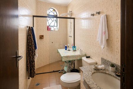 Banheiro com piso de azulejos, pia de granito e porta de vidro com arco. de casa à venda com 3 quartos, 300m² em Rolinópolis, São Paulo