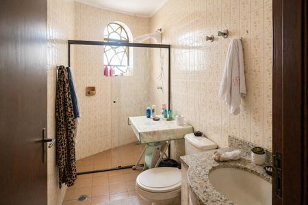Banheiro com chuveiro, pia e vaso sanitário, com iluminação natural e decoração floral. de casa à venda com 3 quartos, 300m² em Rolinópolis, São Paulo