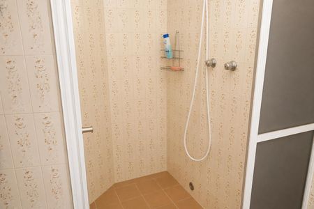 Banheiro com piso de azulejos e paredes de azulejos com decoração floral, com uma pia e uma torneira de chuveiro. de casa à venda com 3 quartos, 300m² em Rolinópolis, São Paulo