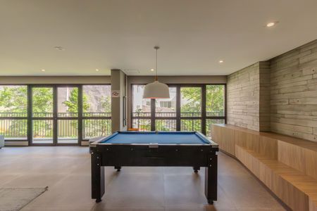 Apartamento à venda com 46m², 2 quartos e 1 vagaTabela de bilhar em sala com vista para a rua e árvores.