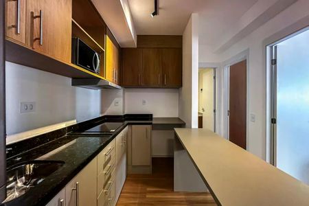 Apartamento à venda com 50m², 2 quartos e 1 vagaCozinha com móveis de madeira e piso de porcelanato, iluminada por luz natural e artificial.