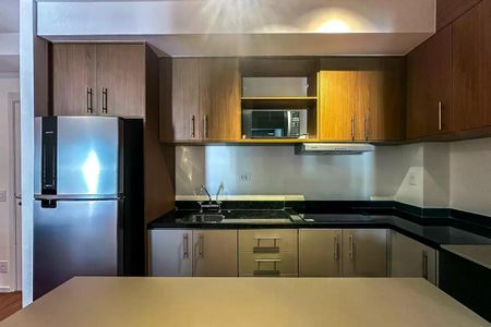 Apartamento à venda com 50m², 2 quartos e 1 vagaCozinha com móveis de madeira e armários de cor creme, com geladeira e fogão.