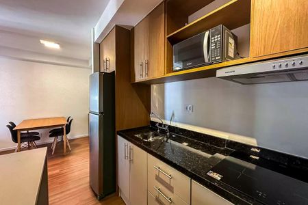 Apartamento à venda com 50m², 2 quartos e 1 vagaCozinha com geladeira, fogão e microondas, com móveis de madeira e piso de porcelanato.