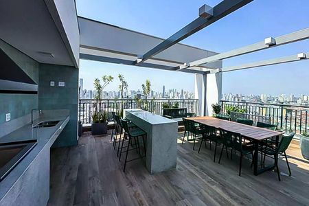 Apartamento à venda com 50m², 2 quartos e 1 vagaVaranda com vista para a cidade, com mesa e cadeiras, e cozinha ao fundo.