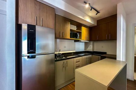 Apartamento à venda com 50m², 2 quartos e 1 vagaCozinha moderna com geladeira, fogão e micro-ondas, iluminada por luzes de LED.