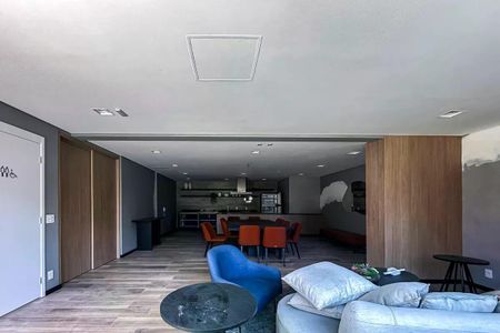 Apartamento à venda com 50m², 2 quartos e 1 vagaSala de estar com sofás, mesas e cadeiras, iluminada por lâmpadas e com uma vista para a rua.