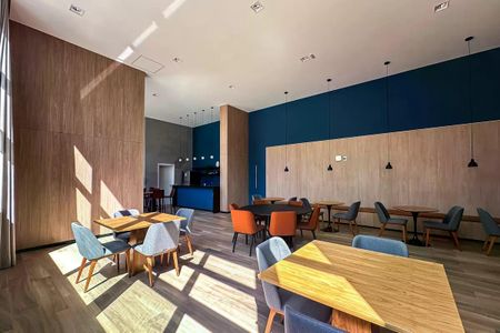 Apartamento à venda com 50m², 2 quartos e 1 vagaSala de reuniões com mesas e cadeiras, iluminação natural, parede em madeira e azul, piso em madeira, iluminação artificial, não há staging.