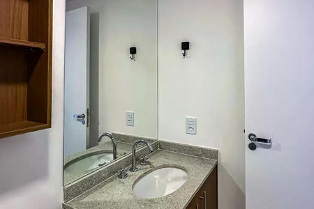 Apartamento à venda com 50m², 2 quartos e 1 vagaBanheiro com pia e espelho, com gavetas e armários, e uma porta branca.