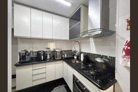 Cozinha com móveis brancos e azuis, iluminada por luzes brancas, com fogão e geladeira, e com uma vista para a cidade. de apartamento à venda com 2 quartos, 62m² em Mandaqui, São Paulo