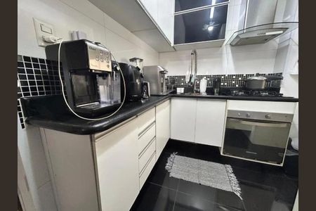 Cozinha com móveis brancos e azulejos pretos, com geladeira, fogão e máquina de café. de apartamento à venda com 2 quartos, 62m² em Mandaqui, São Paulo