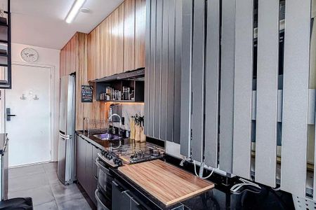 Apartamento à venda com 68m², 3 quartos e 2 vagasCozinha com móveis de madeira, geladeira, fogão e pia, com iluminação boa e bem decorada.