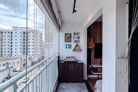 Apartamento à venda com 68m², 3 quartos e 2 vagasBalcony com vista para a cidade, com uma mesa de xadrez e uma guitarra na parede.