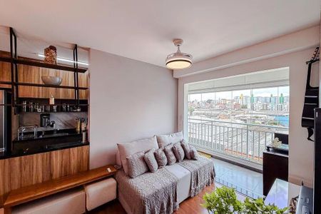 Sala de estar com sofá, mesa e TV, com vista para a cidade. de apartamento à venda com 3 quartos, 68m² em Vila Independencia, São Paulo