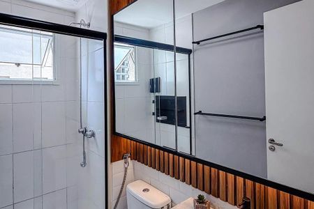 Apartamento à venda com 68m², 3 quartos e 2 vagasBanheiro com piso de porcelanato, teto branco e parede de azulejos brancos, com uma janela pequena e uma porta de vidro.