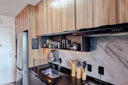 Apartamento à venda com 68m², 3 quartos e 2 vagasCozinha com móveis de madeira, pia e geladeira de aço inox, iluminação boa e organização básica.