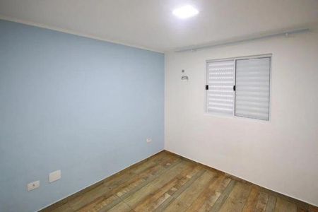 Quarto com paredes azuis e piso de madeira, iluminado por uma lâmpada de teto. de casa à venda com 2 quartos, 150m² em Parque Casa de Pedra, São Paulo