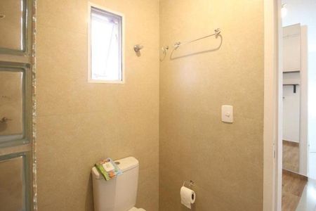 Casa à venda com 150m², 2 quartos e 1 vagaBanheiro com piso de porcelanato, pia e vaso sanitário brancos, e uma janela pequena.