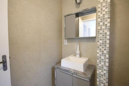 Casa à venda com 150m², 2 quartos e 1 vagaBanheiro com pia e armário de madeira, com teto branco e parede de gesso.
