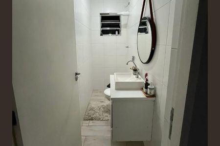 Banheiro com piso de porcelanato, vaso sanitário e lavabo brancos, espelho redondo e prateleira acima do vaso sanitário. de casa à venda com 2 quartos, 150m² em Brasilândia, São Paulo