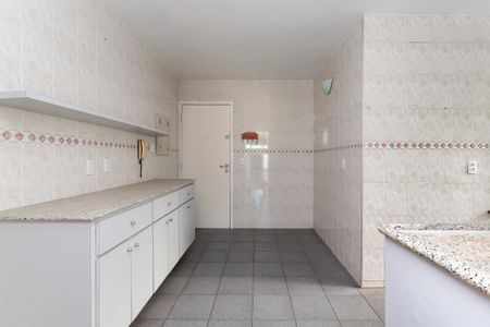 Apartamento à venda com 93m², 3 quartos e 1 vaga Apartamento à venda com 93m², 3 quartos e 1 vagaCozinha com móveis brancos e azulejos brancos e decorativos, com uma porta branca e um telefone no canto.