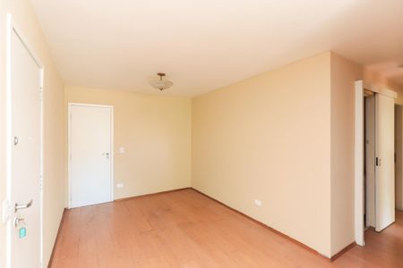 Sala com paredes amarelas e piso de madeira, com uma porta branca e uma lâmpada no teto. de apartamento à venda com 3 quartos, 93m² em Aclimação, São Paulo