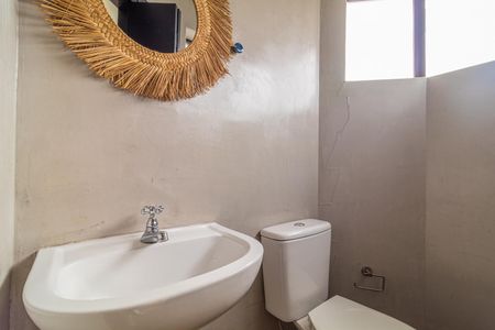 Apartamento à venda com 81m², 2 quartos e 1 vagaBanheiro com pia e vaso sanitário brancos, espelho decorado com palha e janela ao fundo.