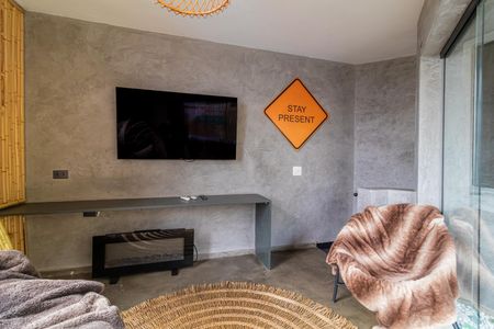 Apartamento à venda com 81m², 2 quartos e 1 vagaQuarto com TV, lareira e sofá confortável, iluminado por luz natural e artificial.