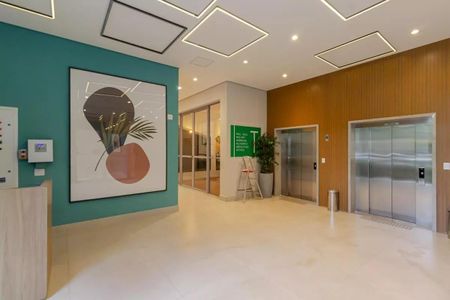 Apartamento à venda com 31m², 1 quarto e sem vaga Apartamento à venda com 31m², 1 quarto e sem vagaParede verde com quadro de arte e elevador de vidro.