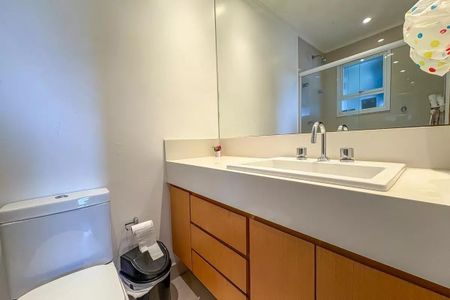 Apartamento à venda com 96m², 4 quartos e 2 vagas Apartamento à venda com 96m², 4 quartos e 2 vagasBanheiro com pia e vaso sanitário brancos, armário de madeira e espelho grande.